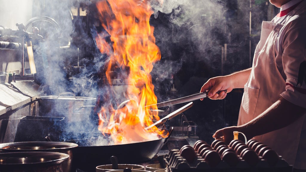 Die besten Tipps zum Kauf einer induktiven Wokpfanne Wok mit Feuer in Küche